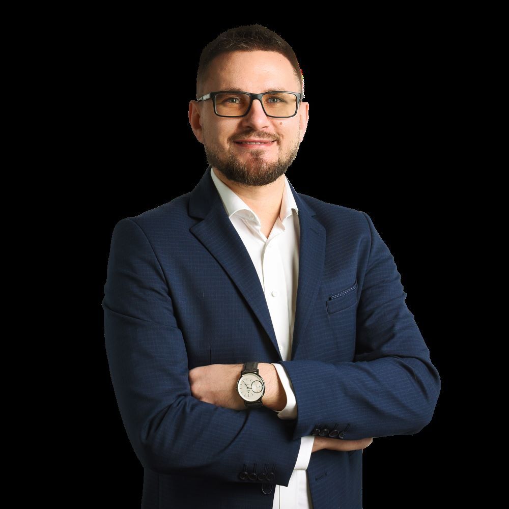 Krzysztof Masłowski-CEO Verseo- z założonymi rękoma na czarnym tle.